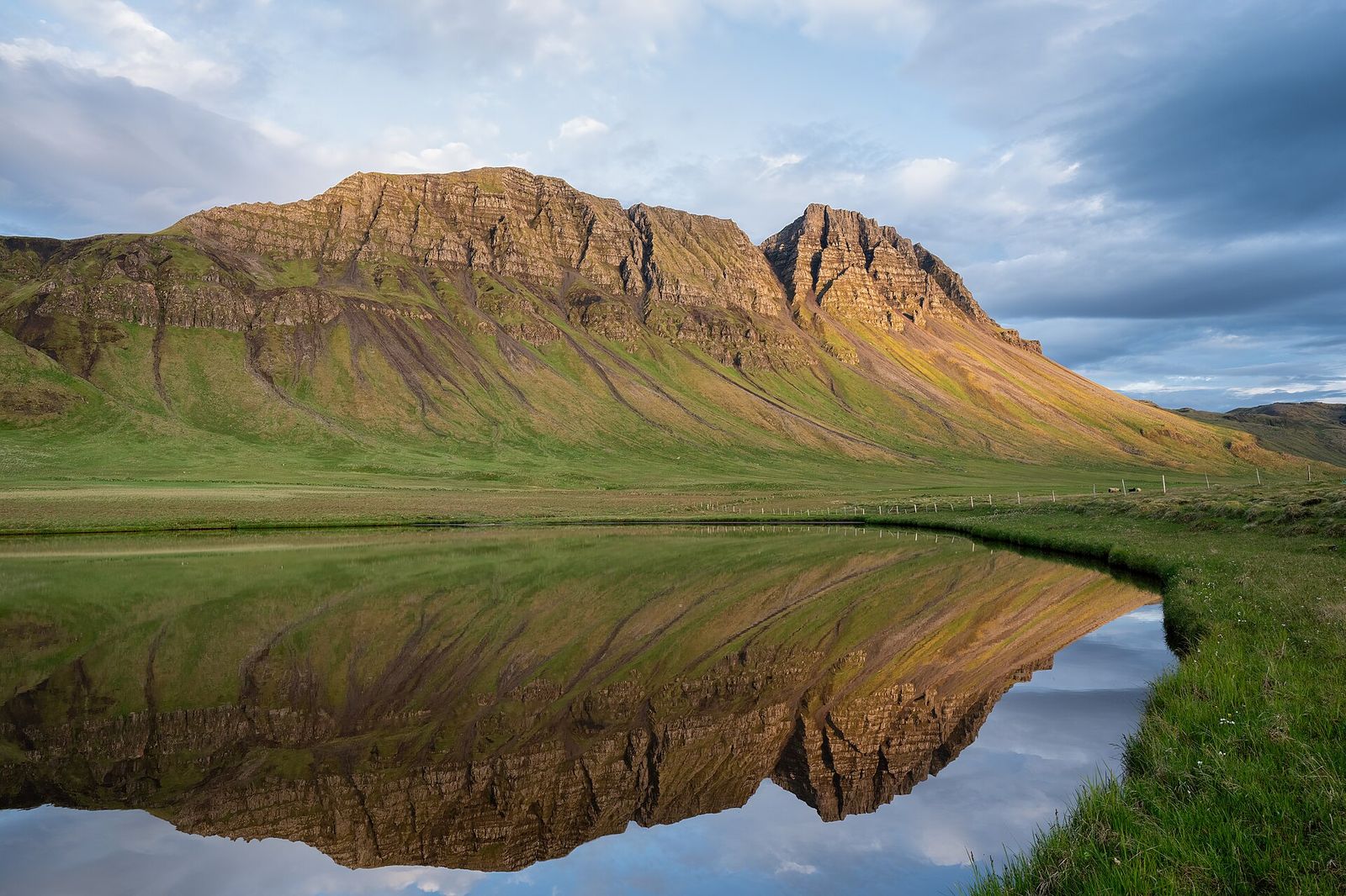 Montanhas islandesas refletidas num lago em silêncio