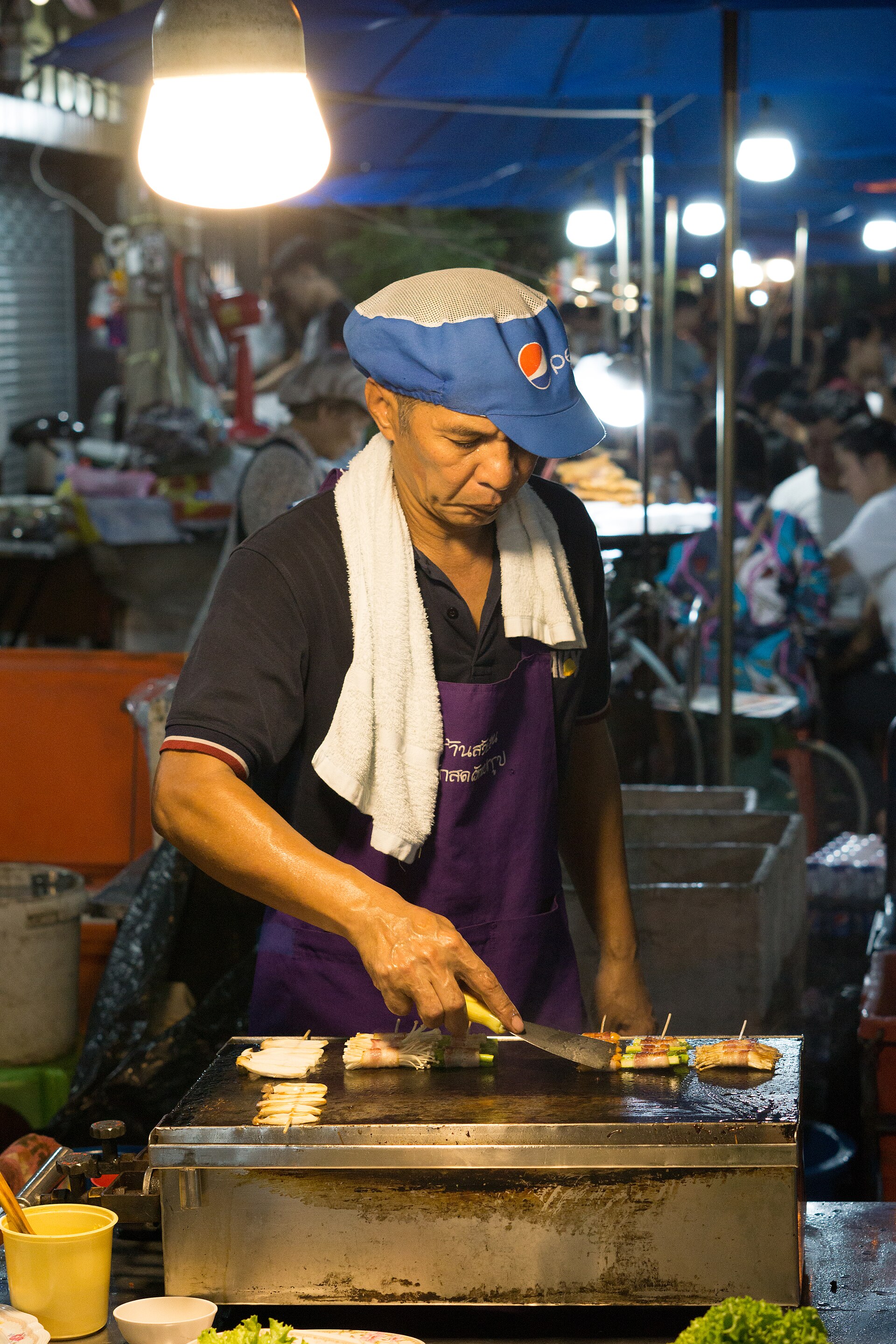 Comida de rua a ser preparada num mercado de Banguecoque