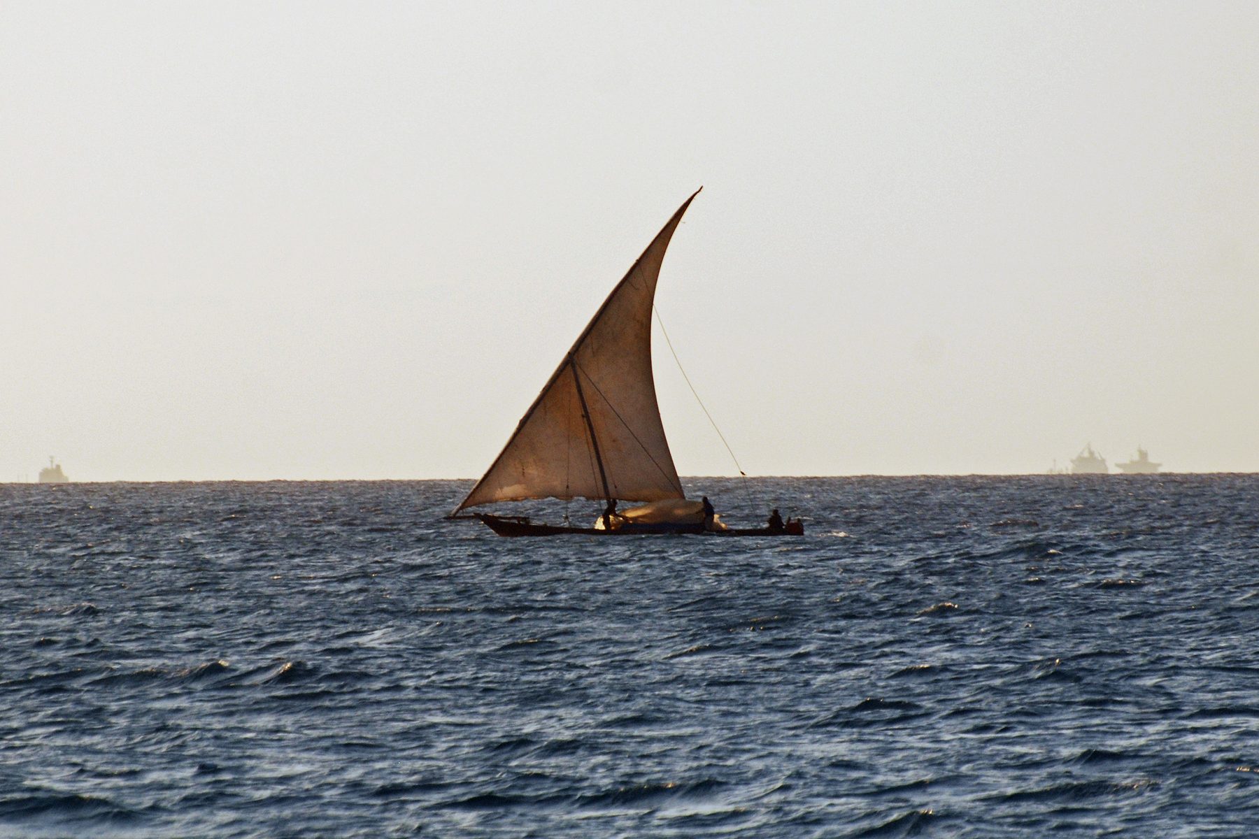Dhow tradicional a navegar ao pôr do sol em Zanzibar
